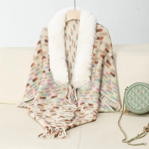 Close-up of knit shawl with faux fur collar, geometric patterns, and long fringe trim