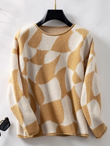 Detail of color-block knit sweater showing geometric mustard yellow and cream texture