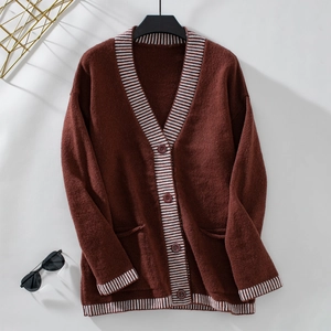 Detail of burgundy knit cardigan featuring striped trims and vintage round buttons