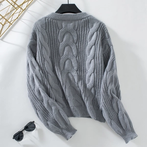 Detail of grey cable-knit texture and thick stitch pattern on a casual women sweater