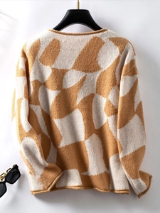 Detailed view of color-block knit sweater texture with soft brown and beige geometric patterns