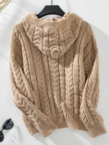 Detailed view of camel cable knit texture and cozy hooded design on winter sweater