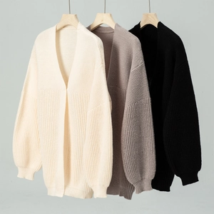 Detailed knit texture and ribbed cuffs of long cardigans in beige, grey, and black