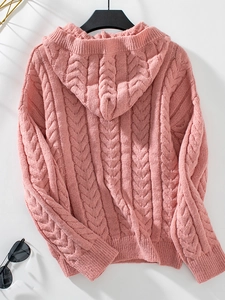 Detail of pink cable knit texture on cozy hooded sweater with rustic button accents