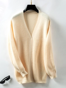 Close-up of cream knit cardigan fabric showing ribbed texture and soft knit details