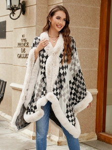 Macro detail of knit checkerboard poncho featuring thick faux fur collar and edges