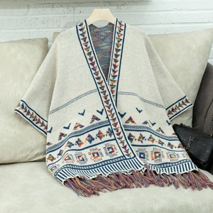Detail eines Bohème-Strickschals mit ethnischen Mustern und bunten langen Fransen