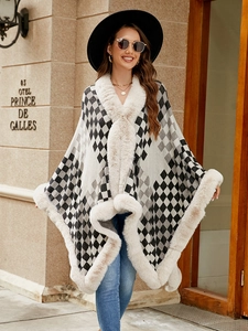 Close-up of thick beige faux fur trim and grey plaid pattern on the knit winter poncho