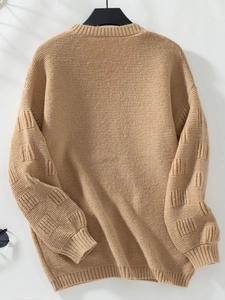 Close-up of khaki knit cardigan showing ribbed cuffs and textured square patterns