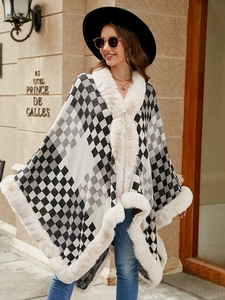 Detail of checkered knit shawl with plush faux fur collar and cuffs on street model