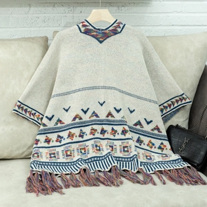 Detaillierte Strickstruktur und bunte Quasten an diesem böhmischen Geometrie-Poncho