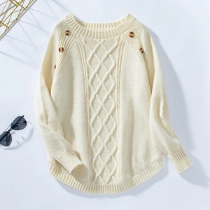 Detail of cable knit sweater with decorative buttons and classic crew neck