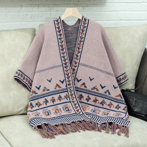 Detail eines Boho-Strickschals mit geometrischen Mustern und bunten Webfransen am Saum
