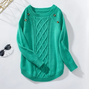 Detail of turquoise cable-knit sweater featuring amber button accents and ribbed texture