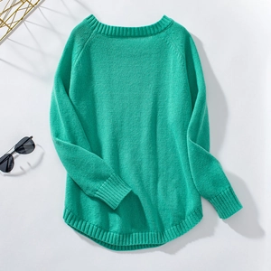 Detail of light green knit sweater featuring a curved hem and ribbed cuffs on white background