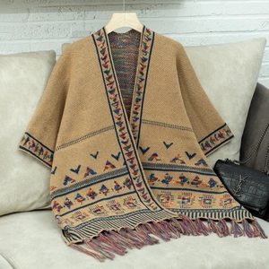 Detail eines ethnischen Strickponchos mit khakifarbenem Muster und bunten Fransen