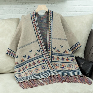 Detail eines Bohème-Strickschals mit ethnischen Mustern und farbigen Fransen am Saum