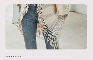 Detailed view of the striped knit poncho fringe hem and textured woven fabric