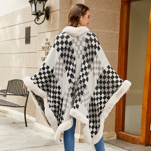 Women's knit poncho with black and white checkerboard pattern and faux fur trim