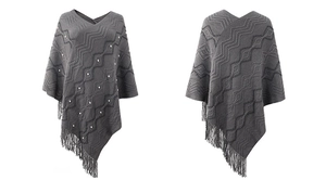 Detail of grey knitted poncho with wave patterns, pearl accents and fringe hem