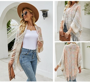 Detail view of knit poncho shawl with colorful stripes and long fringe tassels at hem