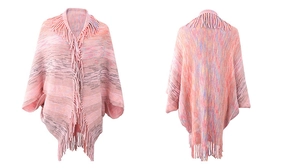 Detail view of pink knit poncho showing long fringe hem and multi-color texture