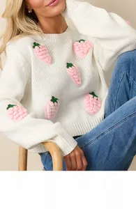 Close-up of 3D crochet strawberry patches on white knit long-sleeve sweater for women