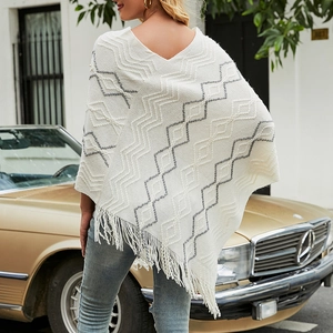 Bohemian knit poncho with chevron patterns and long fringe shown from back outdoor