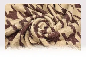 Dettaglio ravvicinato del tessuto a maglia con motivo a stelle beige e marroni e texture