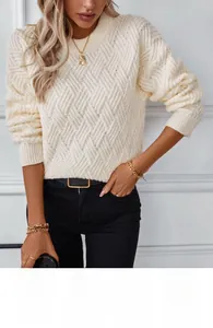 Close-up of geometric embossed cable knit texture on cream-colored crewneck sweater