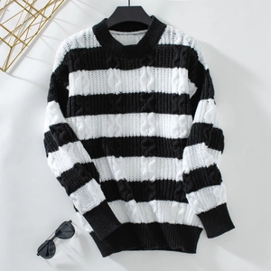 Détail d'un pull rayé noir et blanc en maille torsadée avec col rond pour l'hiver