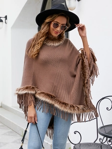 Detailed close-up of brown knitted poncho with faux fur trim and elegant fringe tassels