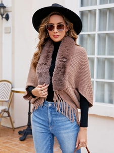 Detail of soft brown knit texture with thick faux fur collar and fringed hemline