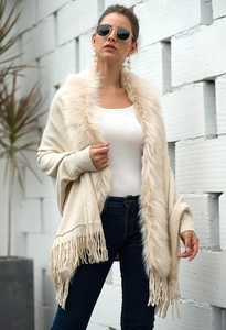 Detail of soft faux fur collar and fringe tassels on beige knit cape shawl cardigan