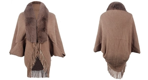 Detail of knit poncho featuring diamond texture, faux fur collar and long fringe trim