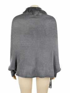 Detail view of the soft knitted fabric and grey faux fur collar on the poncho back