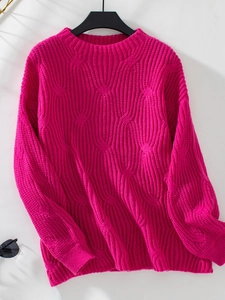 Detail of chunky knit texture and rose red geometric pattern on loose crewneck sweater