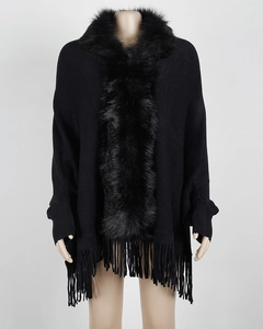 Detailed view of women's black knit poncho with luxury faux fur collar and long fringe hem