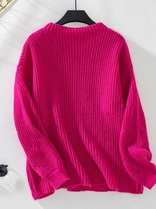Close-up of rose red knit texture and ribbed cuffs on loose long sleeve sweater
