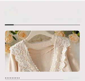 Close-up of elegant lace neckline detail and vertical knit texture on light beige sweater