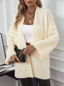 Gros plan sur un cardigan en maille écrue à coupe ample avec des emmanchures tombantes