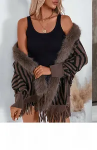 Detail of striped knit poncho featuring elegant faux fur collar and fringe tassels