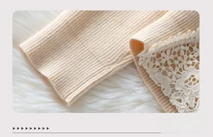 Close-up of ribbed knit cuffs with delicate floral lace trim on a beige sweater