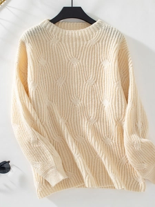 Detailed view of beige chunky knit sweater featuring thick textured cable stitch patterns