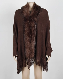 Close-up of brown knit poncho featuring faux fur collar and long fringe tassel hem