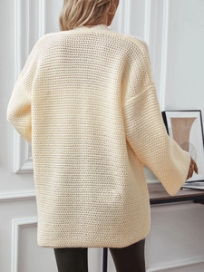 Gilet en maille épaisse beige oversize à manches longues dans un cadre intérieur chaleureux