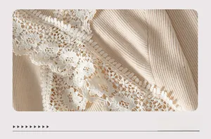 Macro detail of cream ribbed knit fabric with delicate floral lace trim embroidery