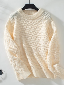Close-up of cream cable-knit sweater texture with premium ribbed crew neck detail