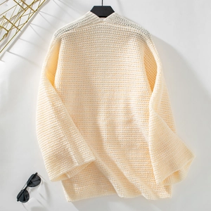 Gros plan du cardigan en grosse maille crème avec rayures texturées et poignets côtelés