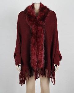 Detail of burgundy knit poncho with soft faux fur collar and fringe hem styling